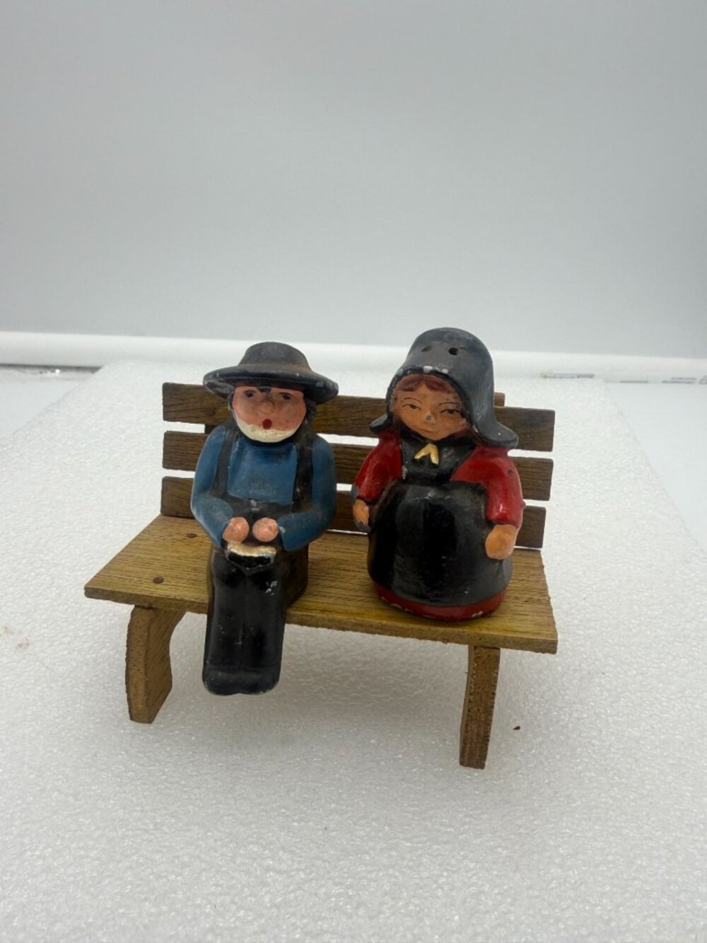Vintage Cast Iron Amish Couple Salt and Pepper Shakers on Wood Bench